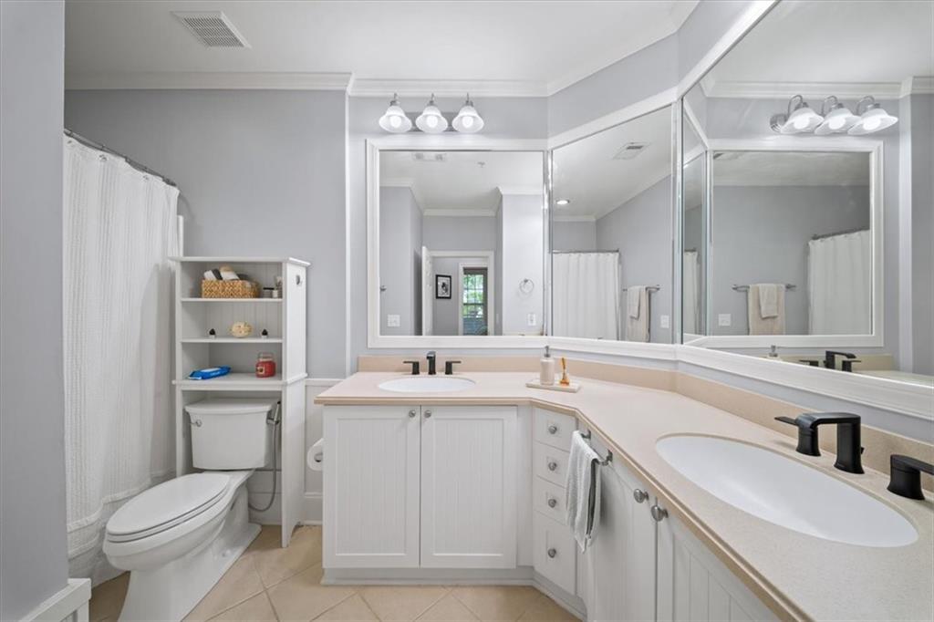 4100 Paces Walk Southeast, Unit 1101 Atlanta, GA 30339 - Photo 24 of 36 a bathroom with a sink a toilet a large mirror and vanity