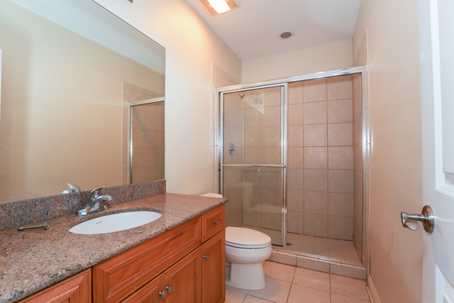 1059 Shermer Road Northbrook, IL 60062 - Photo 23 of 23 a bathroom with a granite countertop sink toilet and shower