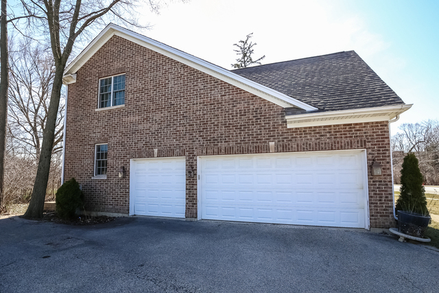 1059 Shermer Road Northbrook, IL 60062 - Photo 4 of 23 a front view of a house with a yard and garage