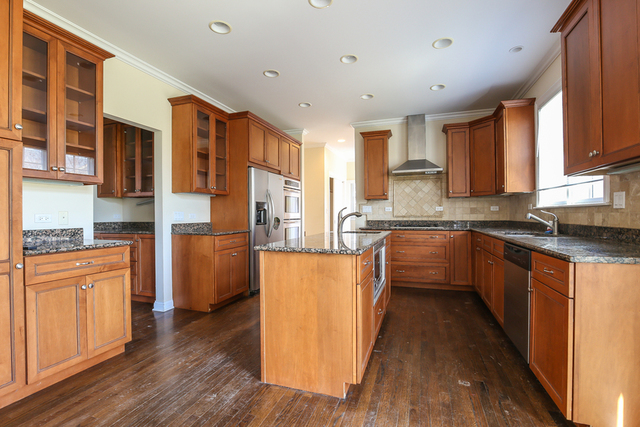 1059 Shermer Road Northbrook, IL 60062 - Photo 8 of 23 a kitchen with stainless steel appliances granite countertop a refrigerator a sink dishwasher a stove top oven a large island with wooden floor and cabinets