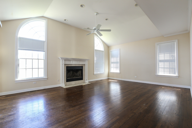 1059 Shermer Road Northbrook, IL 60062 - Photo 10 of 23 an empty room with wooden floor fireplace and windows