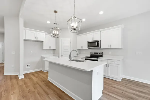 a kitchen with a sink stainless steel appliances and white cabinets