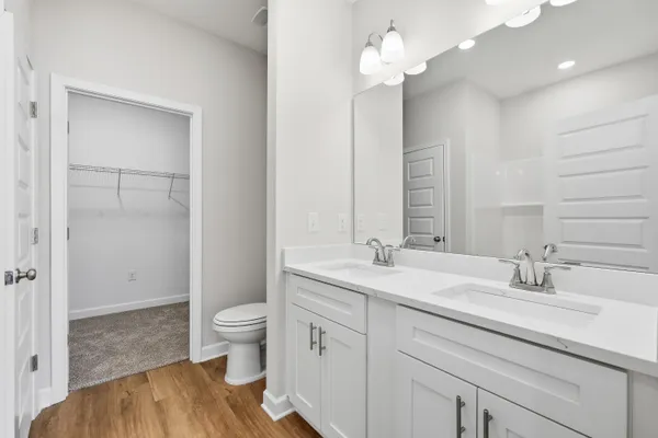 a spacious bathroom with a granite countertop sink a toilet and a mirror