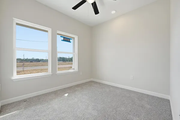 an empty room with a window and a ceiling fan