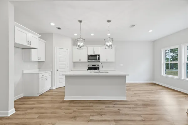 a view of kitchen with granite countertop stainless steel appliances sink and stove