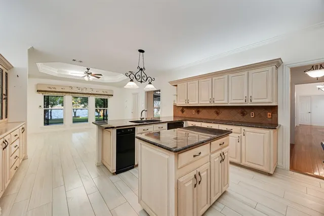 a kitchen with granite countertop stainless steel appliances a sink stove and cabinets