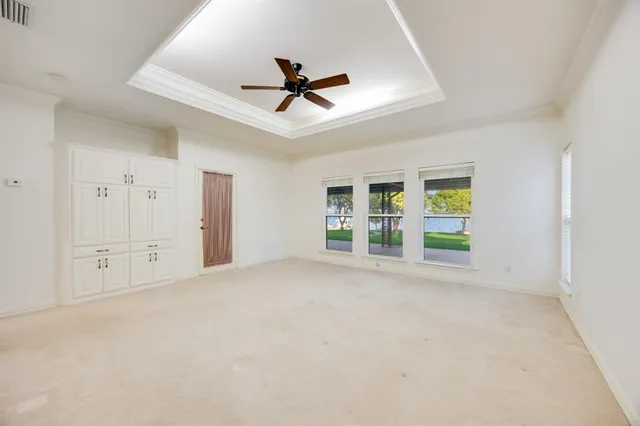 an empty room with windows and cabinet