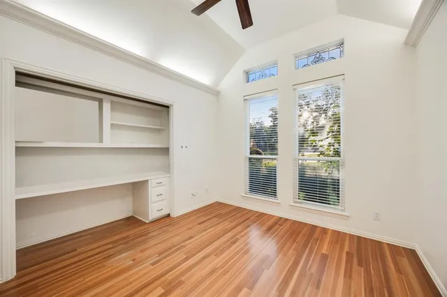an empty room with closet and windows
