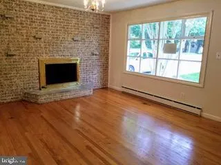 a view of empty room with wooden floor and fireplace