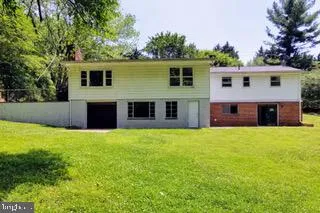 a front view of house with yard and trees in the background