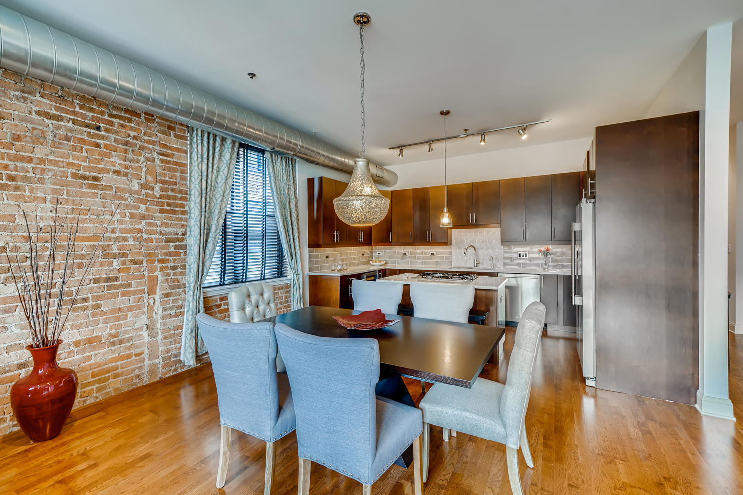 23 North Green Street, Unit 401 Chicago, IL 60607 - Photo 4 of 17 a kitchen with stainless steel appliances kitchen island granite countertop a dining table chairs and a refrigerator