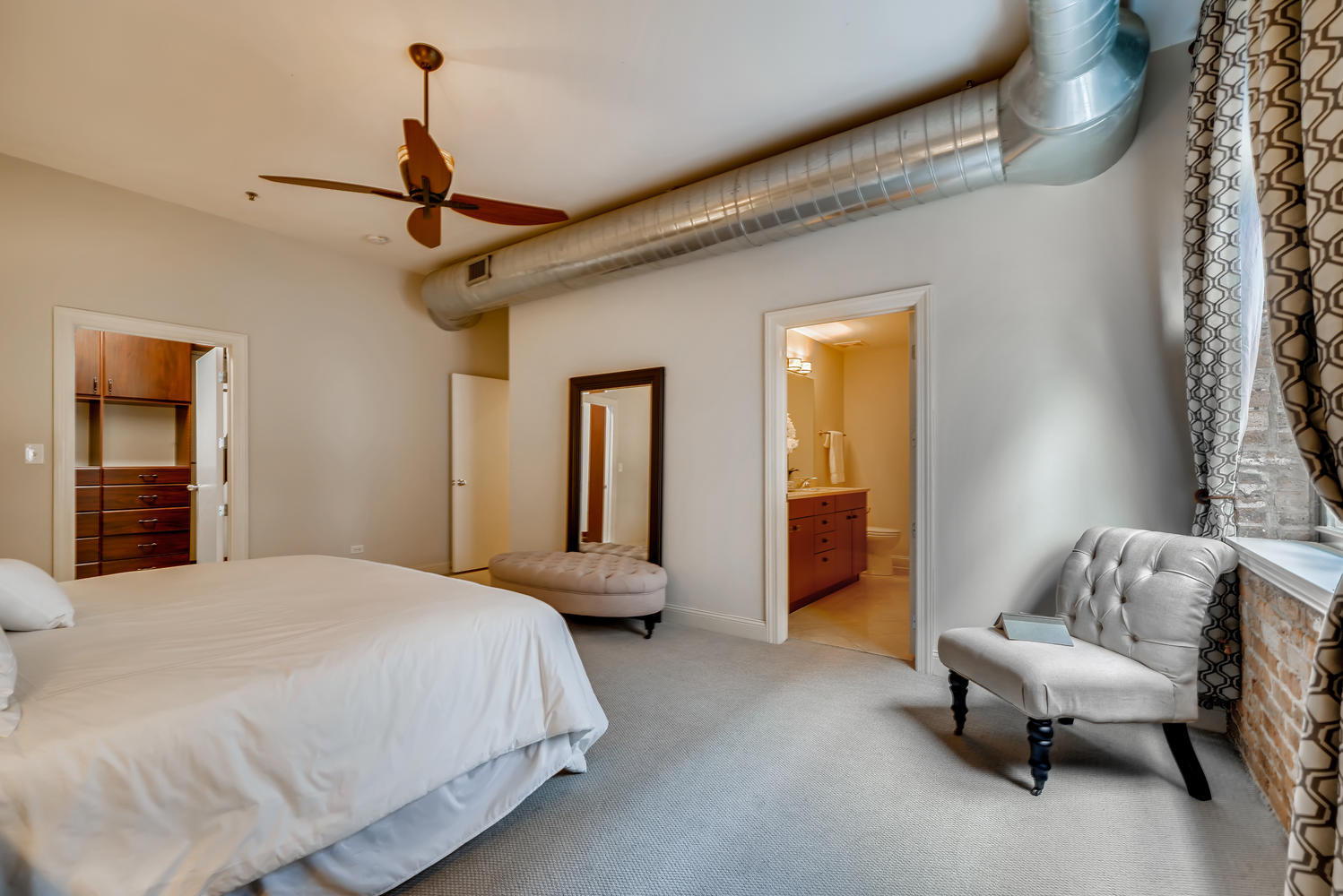 23 North Green Street, Unit 401 Chicago, IL 60607 - Photo 8 of 17 a spacious bedroom with a bed and a chandelier