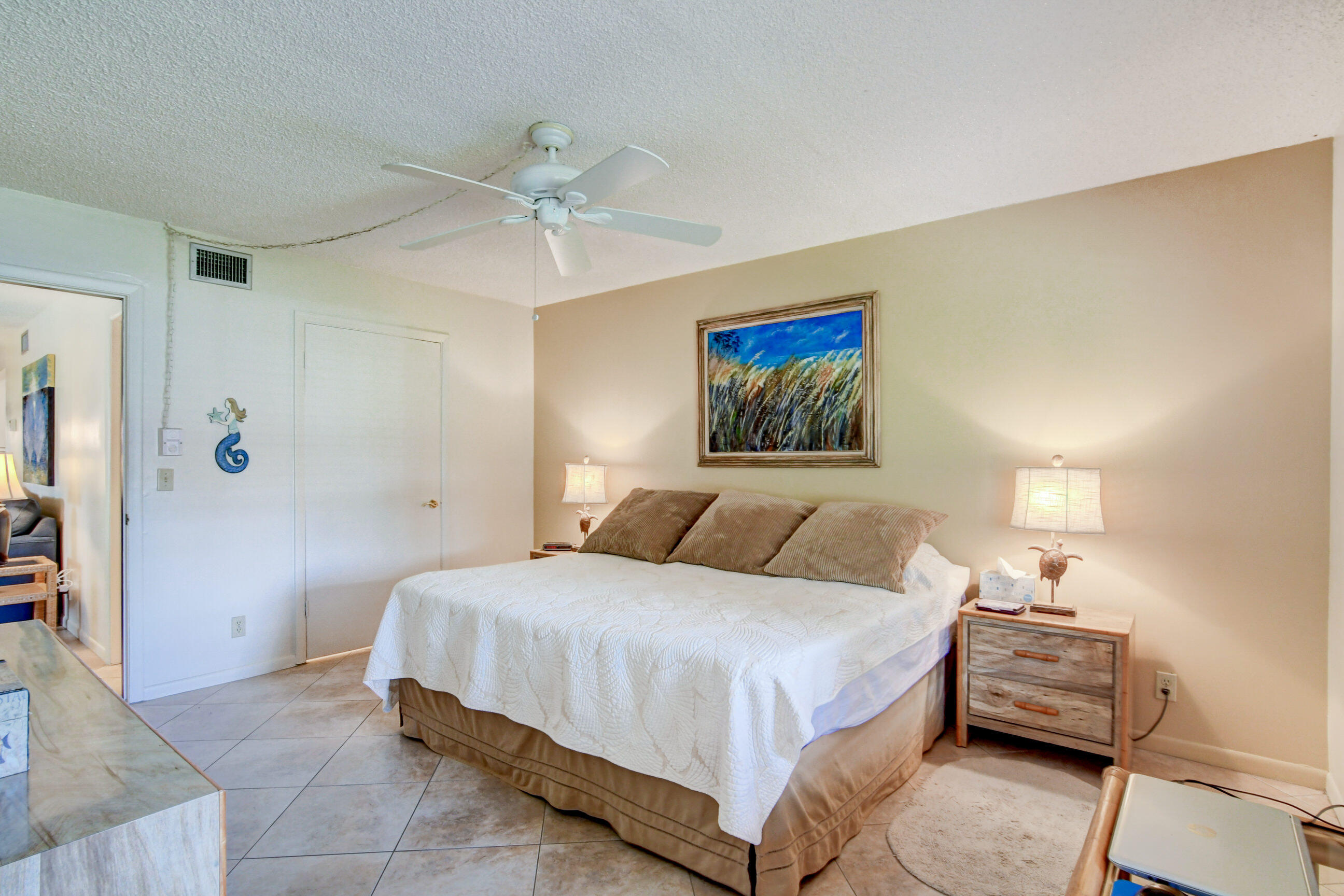 334 Pine Ridge Circle, Unit B1 Greenacres, FL 33463 - Photo 13 of 26 a bedroom with a bed and a chandelier