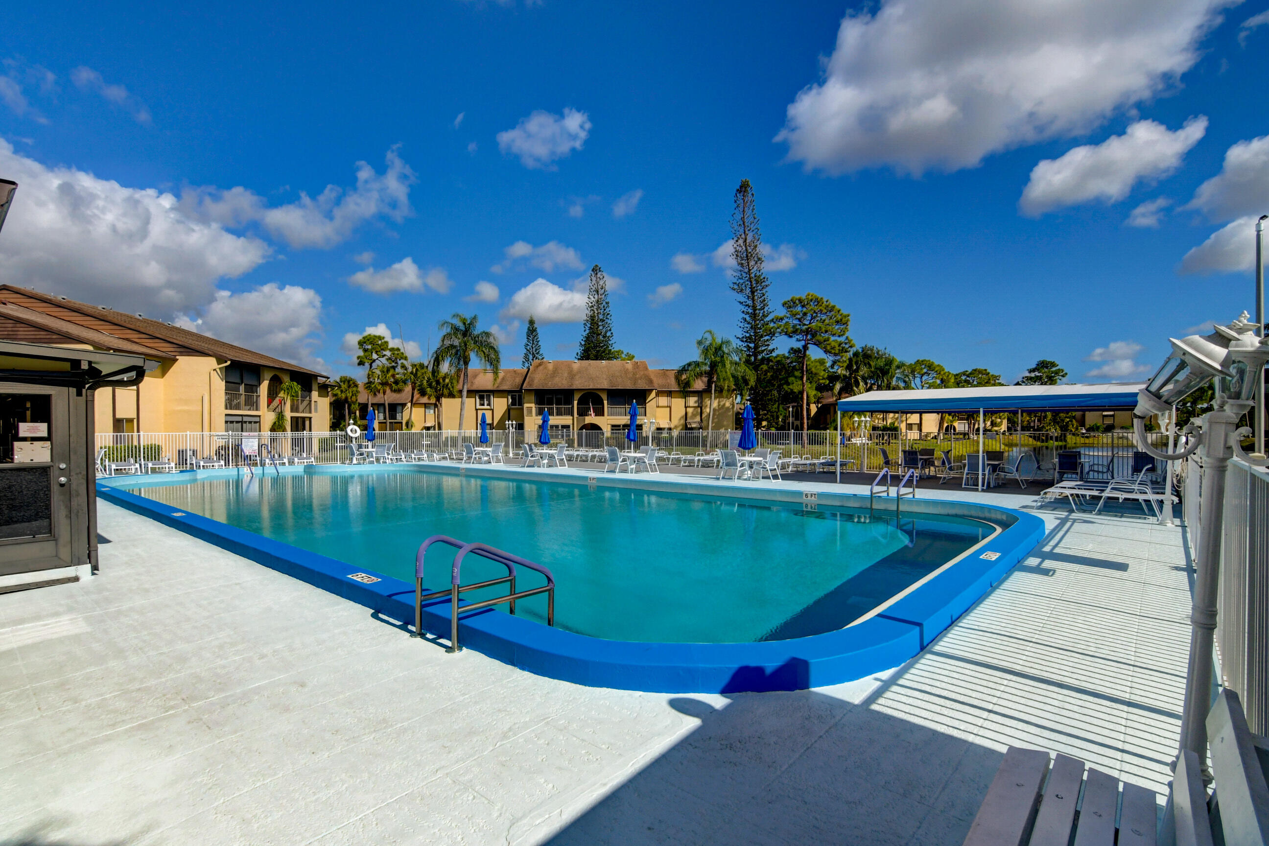 334 Pine Ridge Circle, Unit B1 Greenacres, FL 33463 - Photo 22 of 26 a view of a swimming pool with outdoor seating