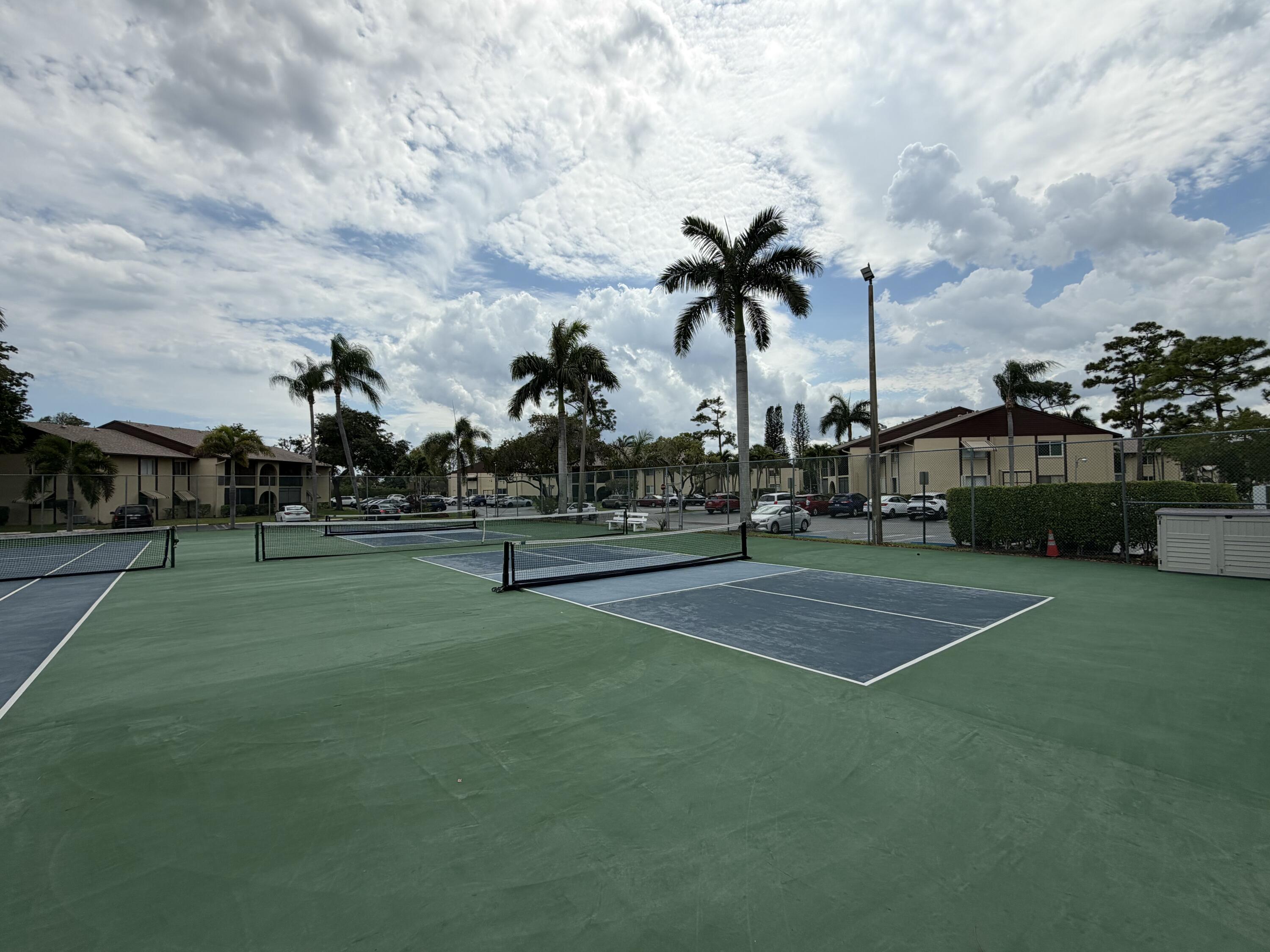 334 Pine Ridge Circle, Unit B1 Greenacres, FL 33463 - Photo 24 of 26 a view of a playground apartment building and trees