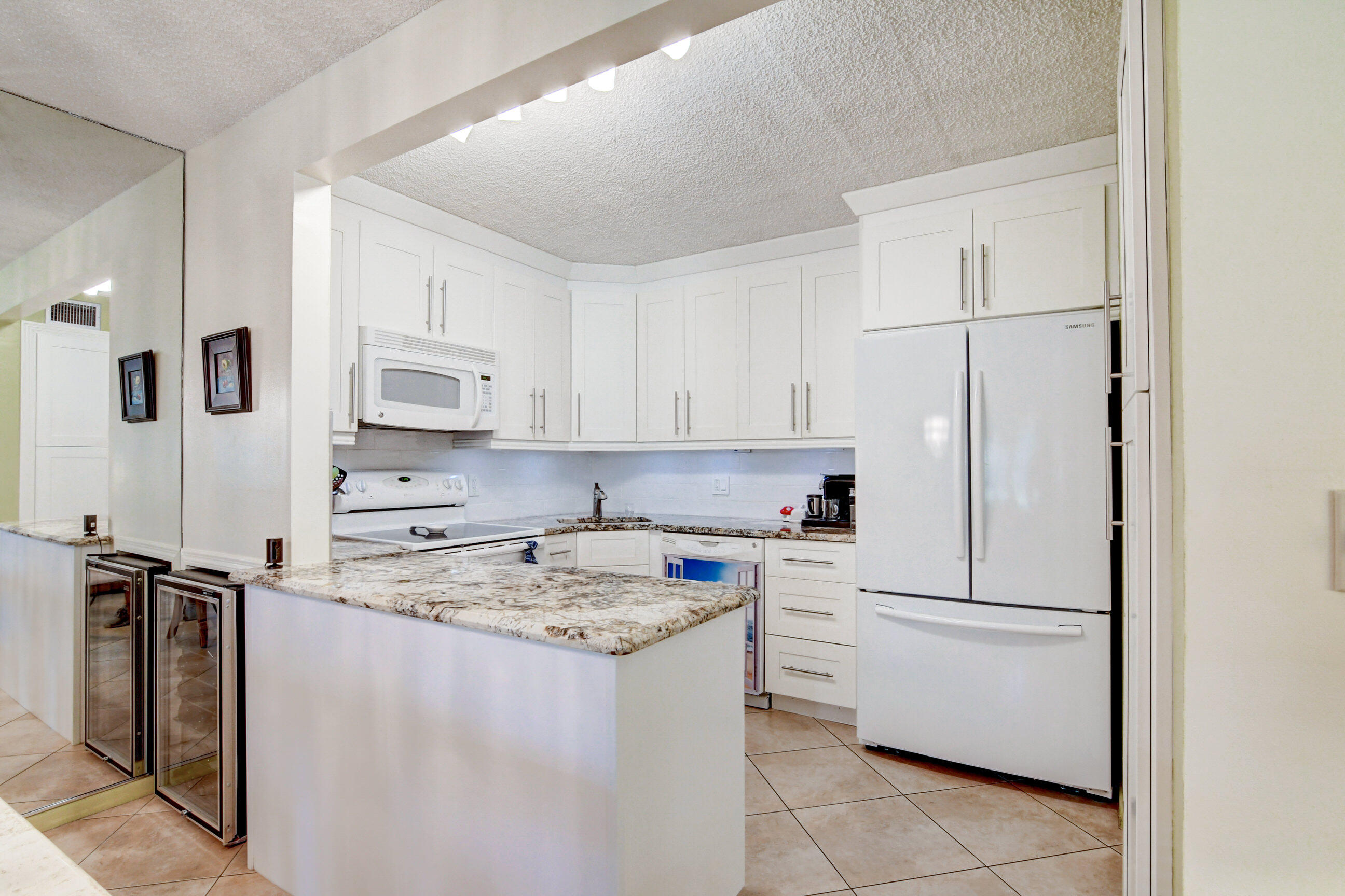 334 Pine Ridge Circle, Unit B1 Greenacres, FL 33463 - Photo 9 of 26 a kitchen with a refrigerator sink stove and cabinets