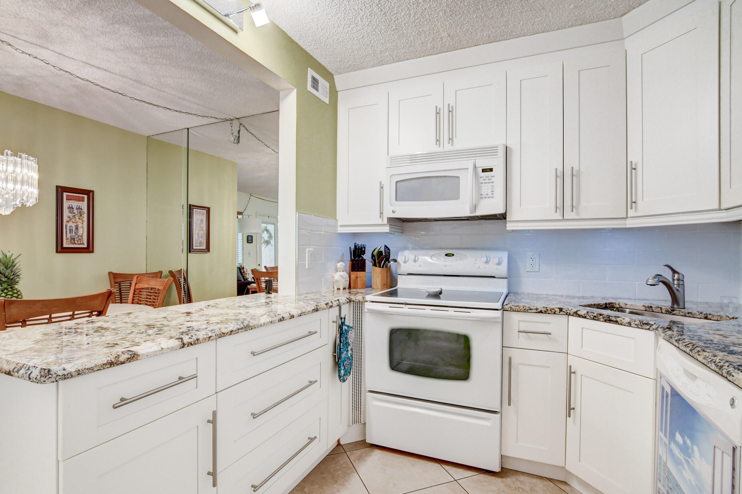 334 Pine Ridge Circle, Unit B1 Greenacres, FL 33463 - Photo 10 of 26 a kitchen with granite countertop white cabinets and white appliances