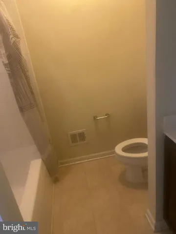 a bathroom with a granite countertop toilet and a shower