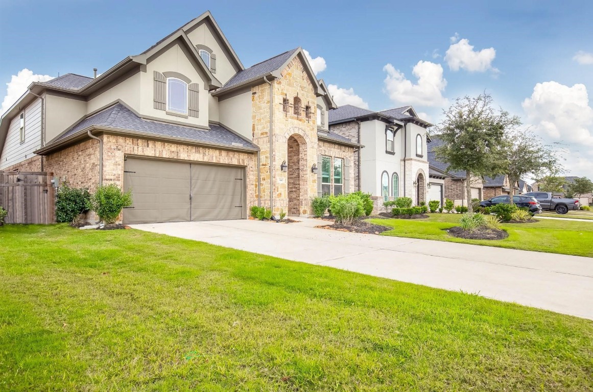 3443 Cabernet Shores Drive Fulshear, TX 77441 - Photo 2 of 27 a front view of a house with a garden and plants