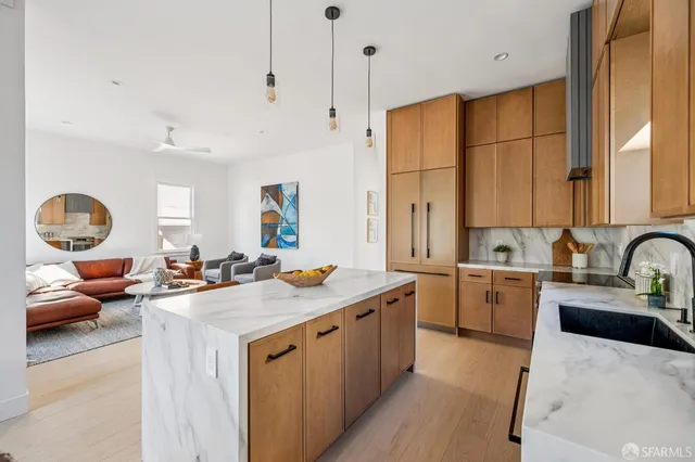 a view of a kitchen with a sink a counter top space and living room