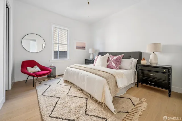 a bedroom with a bed a dresser and chair