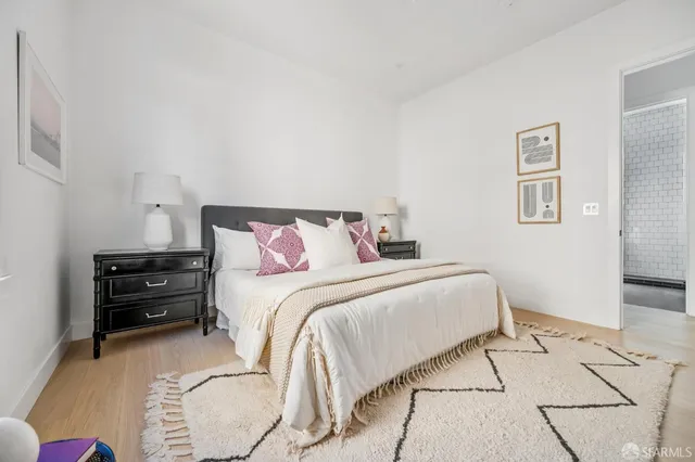 a bedroom with a bed and a wooden floor