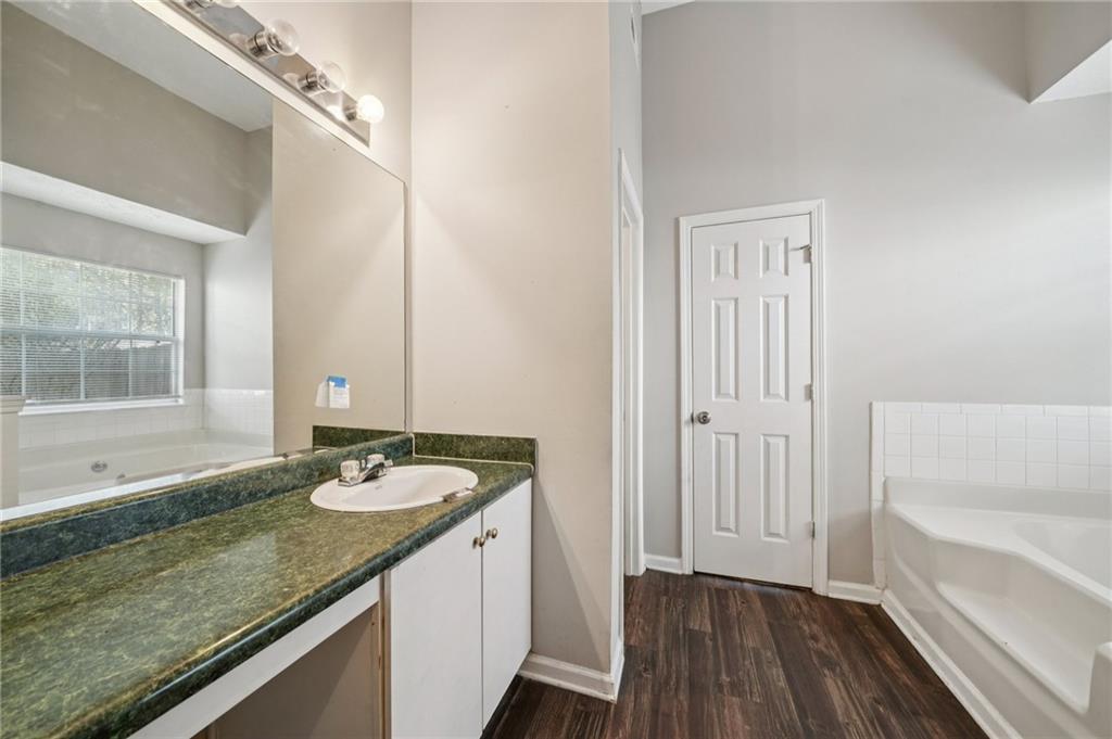 1443 Pebble Ridge Lane Hampton, GA 30228 - Photo 16 of 24 a bathroom with a granite countertop sink and a bathtub