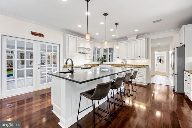 a kitchen with kitchen island granite countertop a sink a stove and cabinets