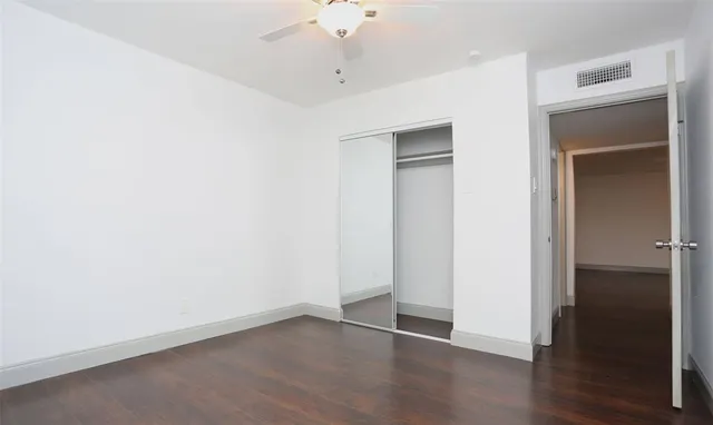 an empty room with wooden floor and closet