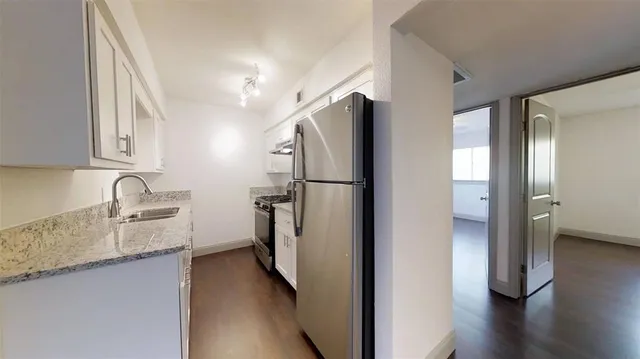 a kitchen with stainless steel appliances granite countertop a refrigerator and a sink