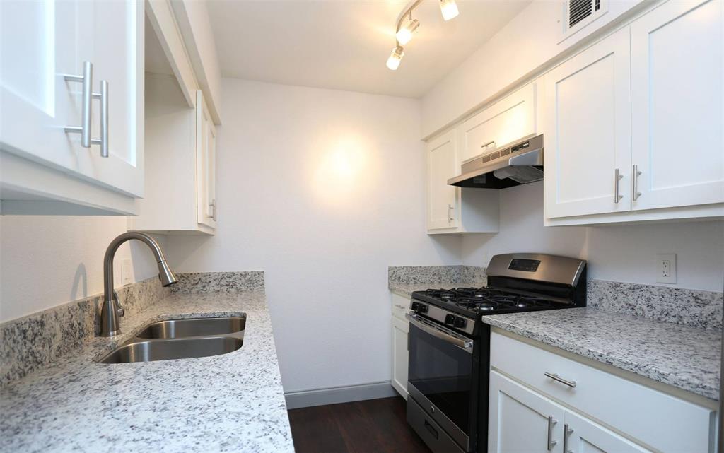 404 East 9th Street, Unit 8102 Dallas, TX 75203 - Photo 6 of 15 a kitchen with stainless steel appliances granite countertop a sink stove and refrigerator
