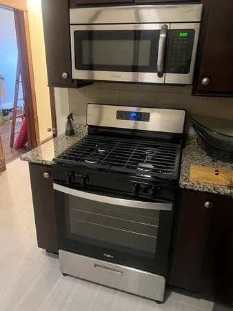 a kitchen with granite countertop a stove and a microwave