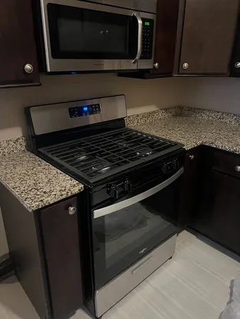 a kitchen with sink a microwave and cabinets