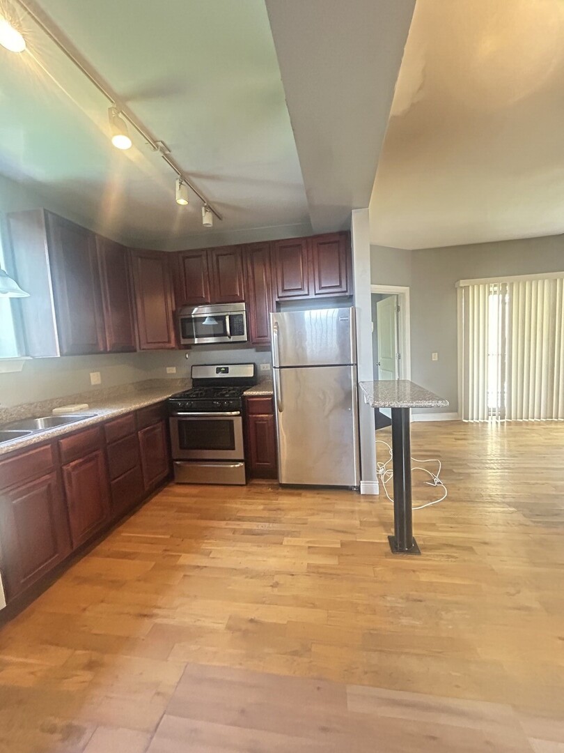 1464 East 69th Street, Unit 2N Chicago, IL 60637 - Photo 8 of 15 a kitchen with stainless steel appliances granite countertop a refrigerator sink and cabinets
