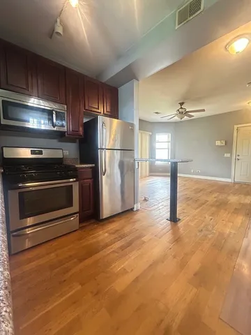 a kitchen with stainless steel appliances granite countertop a stove a sink and a microwave