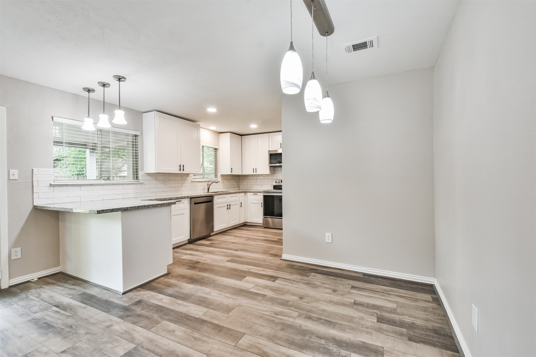 6103 Fallengate Drive Spring, TX 77373 - Photo 14 of 36 a large kitchen with granite countertop a white cabinets stainless steel appliances and a chandelier