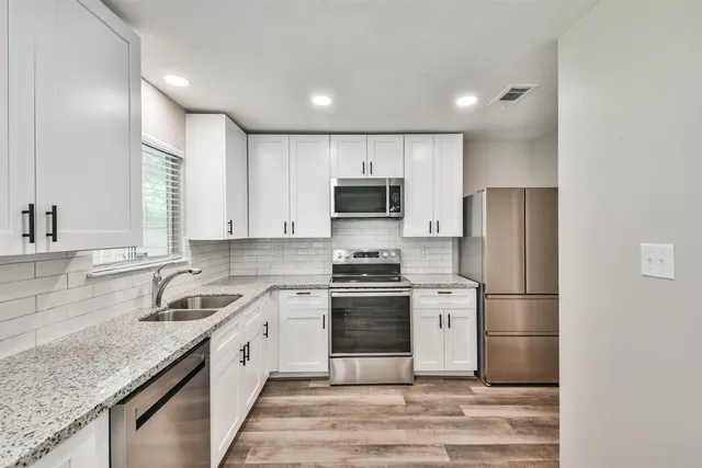 a kitchen with stainless steel appliances a sink stove and microwave