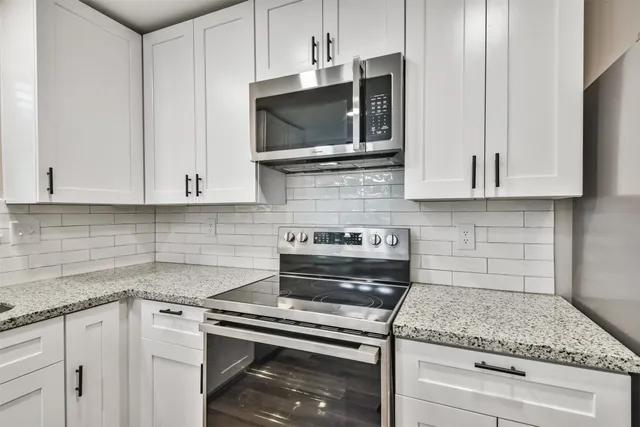 a large kitchen with cabinets and wooden floor