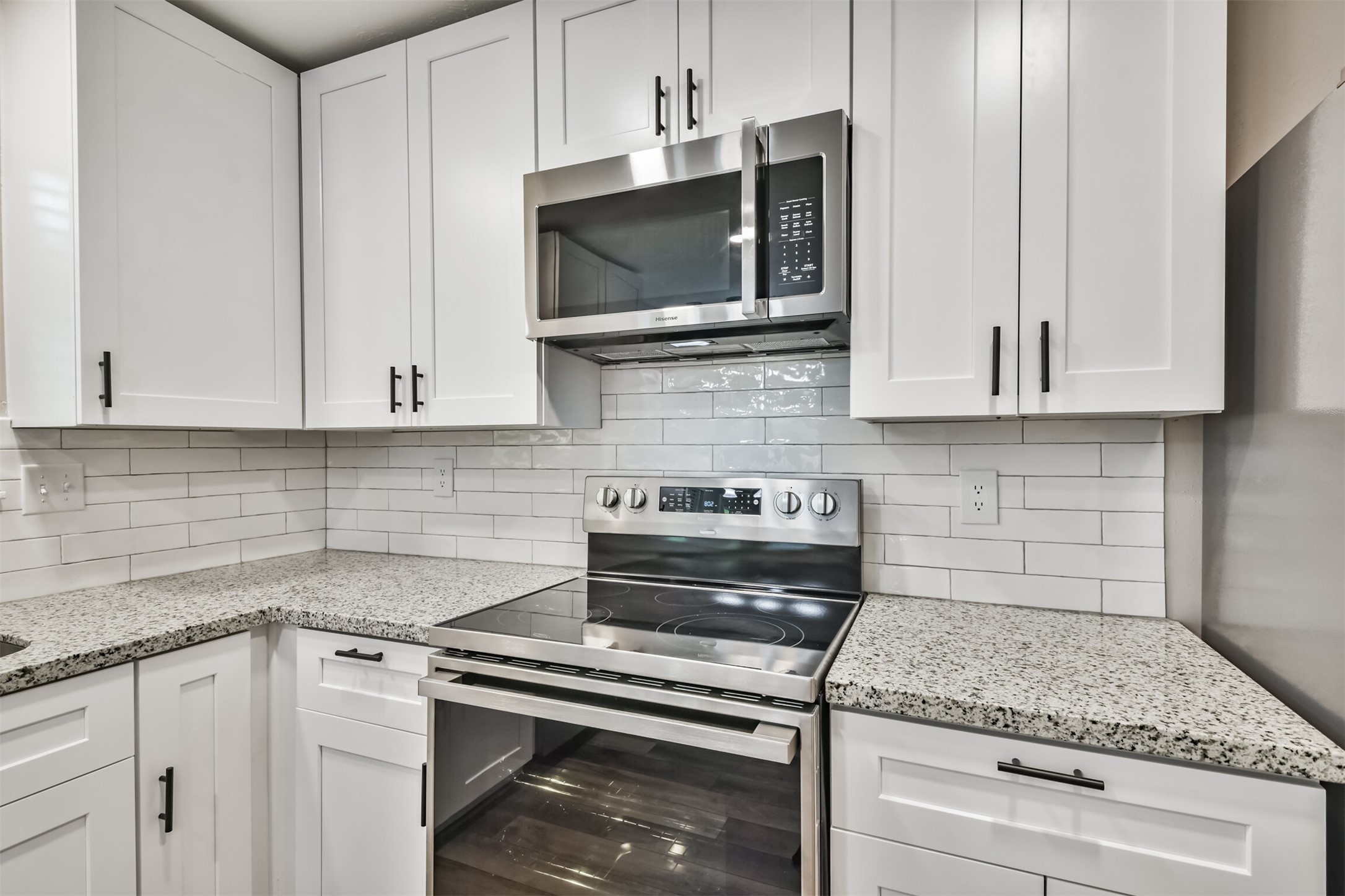 6103 Fallengate Drive Spring, TX 77373 - Photo 19 of 36 a kitchen with stainless steel appliances granite countertop white cabinets stove a sink and dishwasher
