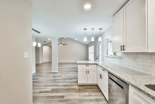 a kitchen with stainless steel appliances white cabinets and a granite counter top