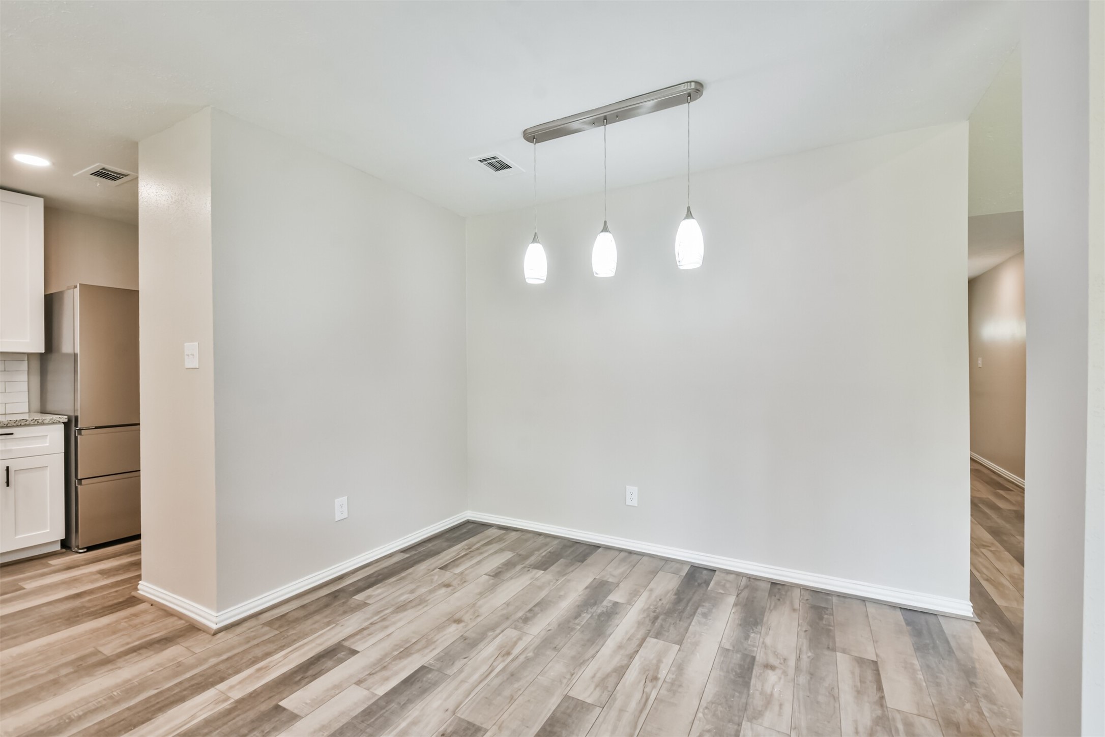 6103 Fallengate Drive Spring, TX 77373 - Photo 23 of 36 a view of empty room with wooden floor and kitchen