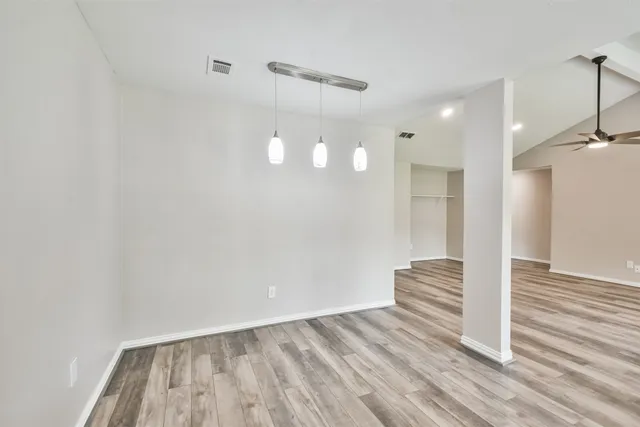 a view of a kitchen with wooden floor and a window