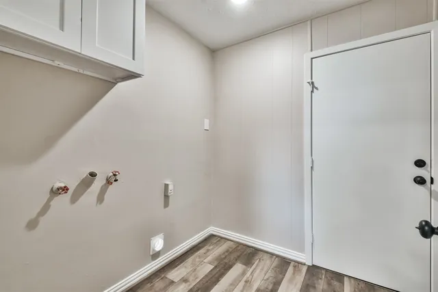 an empty room with wooden floor ceiling fan and windows