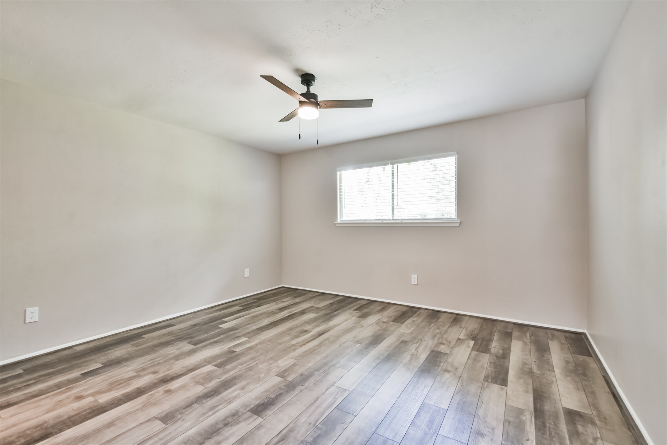 6103 Fallengate Drive Spring, TX 77373 - Photo 28 of 36 an empty room with wooden floor ceiling fan and windows