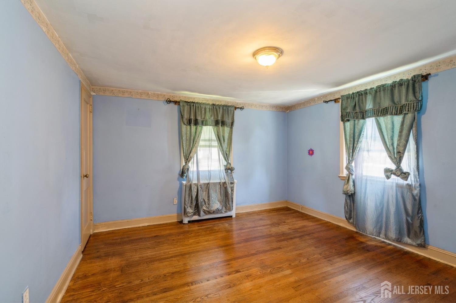 571 Greenbrook Road North Plainfield, NJ 07063 - Photo 13 of 28 an empty room with wooden floor and windows