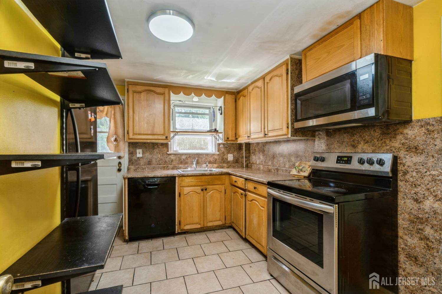 571 Greenbrook Road North Plainfield, NJ 07063 - Photo 17 of 28 a kitchen with stainless steel appliances granite countertop a stove microwave and sink