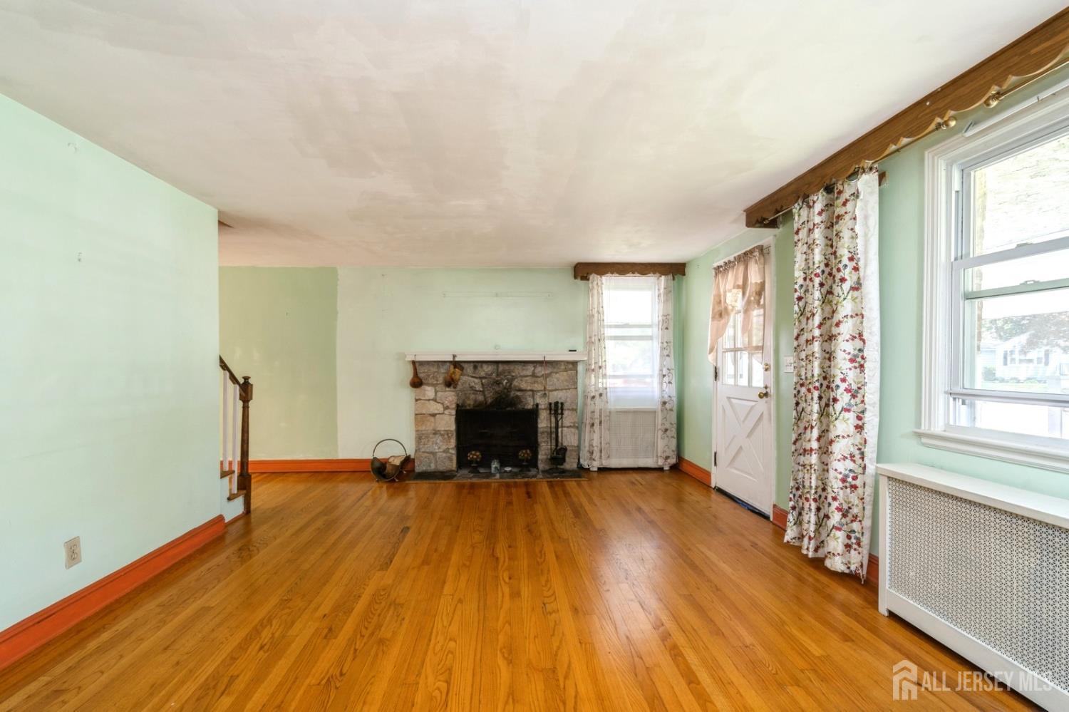 571 Greenbrook Road North Plainfield, NJ 07063 - Photo 9 of 28 a view of empty room with wooden floor and fireplace