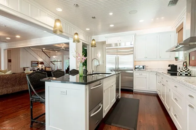 a kitchen with stainless steel appliances kitchen island granite countertop a sink and cabinets
