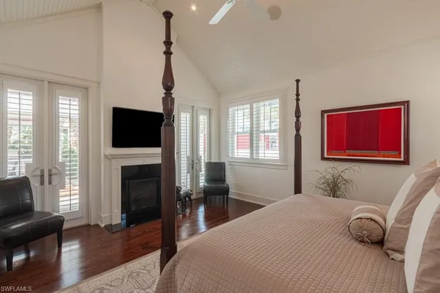 a bedroom with a bed a window and a flat screen tv