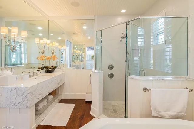 a bathroom with a granite countertop sink a large mirror and shower